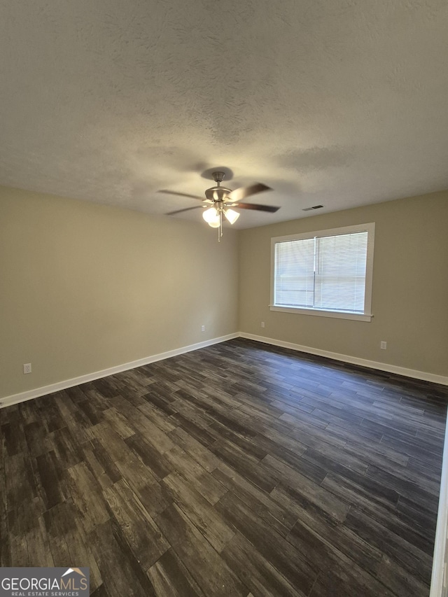 unfurnished room featuring dark wood-style floors, a ceiling fan, baseboards, and a textured ceiling