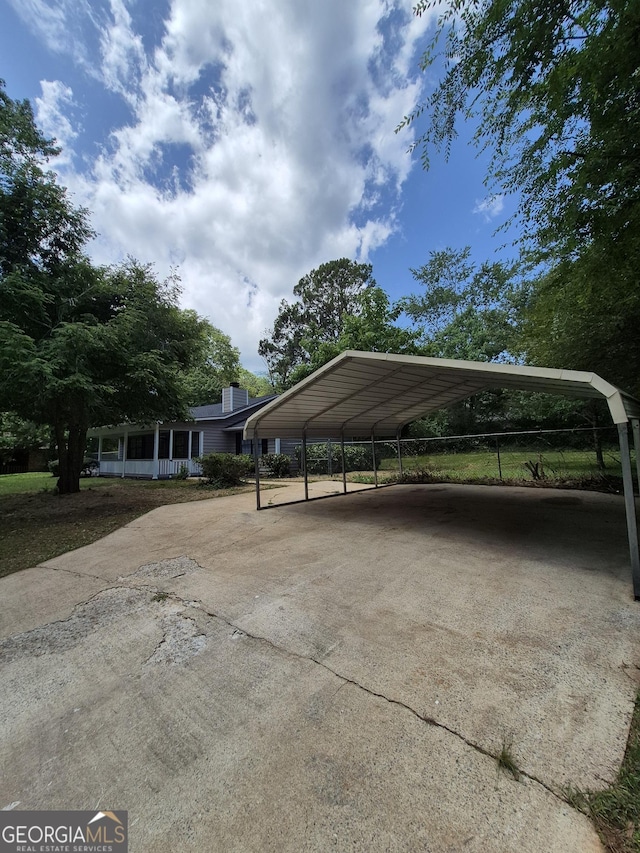 view of parking / parking lot with driveway and a detached carport