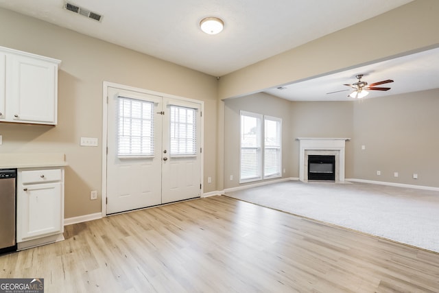 11576 Kades Trl, Hampton, GA 30228 - kitchen featuring white cabinetry, a fireplace with flush hearth, light wood-style flooring, baseboards, and ceiling fan