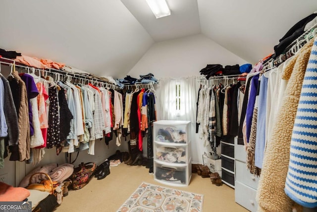 walk in closet with vaulted ceiling and carpet