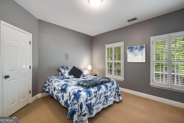 bedroom with carpet, multiple windows, and baseboards