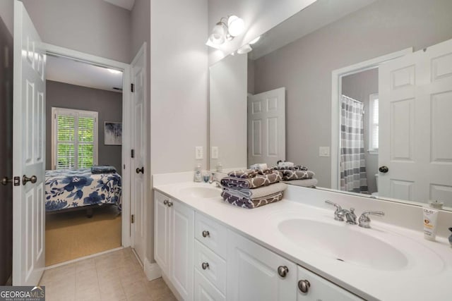 bathroom with double vanity, tile patterned floors, and connected bathroom