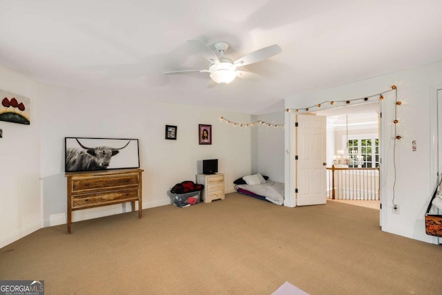 interior space with a ceiling fan, carpet floors, and baseboards