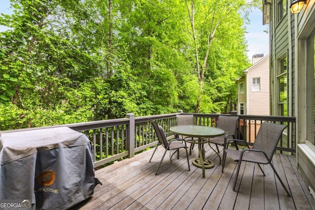 deck featuring outdoor dining space and a grill