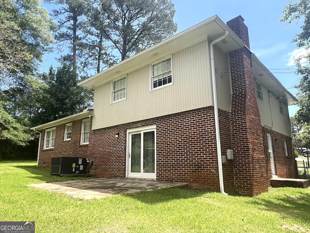 443 S Rays Rd, Stone Mountain, GA 30083 - rear view of house featuring a chimney, central AC, a lawn, brick siding, and a patio