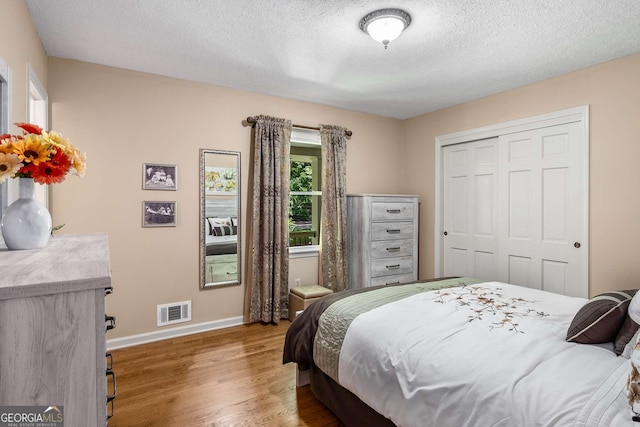 5401 Rosser Rd, Tucker, GA 30087 - bedroom with wood finished floors, a textured ceiling, and a closet