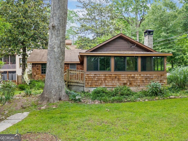 4624 Park Dr, Pine Lake, GA 30072 - view of front of house featuring a chimney, a front yard, a shingled roof, and a sunroom