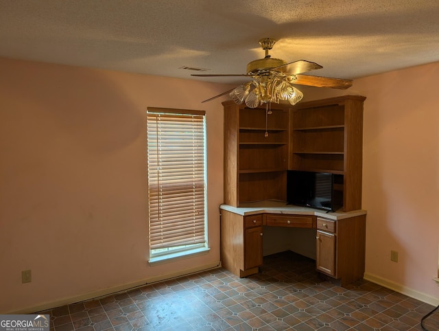 5700 Miles Rd, South Fulton, GA 30349 - unfurnished office with built in desk, a ceiling fan, baseboards, a textured ceiling, and plenty of natural light