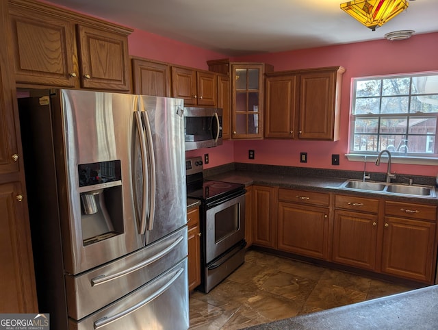 5700 Miles Rd, South Fulton, GA 30349 - kitchen featuring appliances with stainless steel finishes, a sink, brown cabinets, dark countertops, and glass insert cabinets