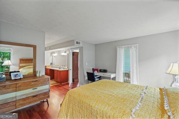 212 Brittany Ct, Duluth, GA 30096 - bedroom with wood finished floors, multiple windows, and connected bathroom