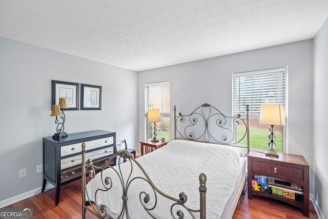 212 Brittany Ct, Duluth, GA 30096 - bedroom featuring wood finished floors, multiple windows, baseboards, and a textured ceiling