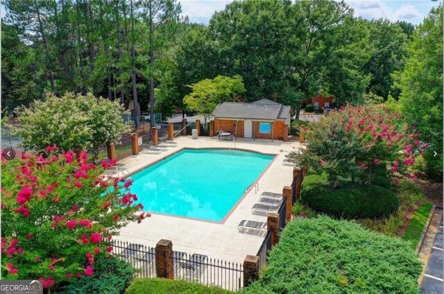 212 Brittany Ct, Duluth, GA 30096 - community pool with a patio and an outbuilding