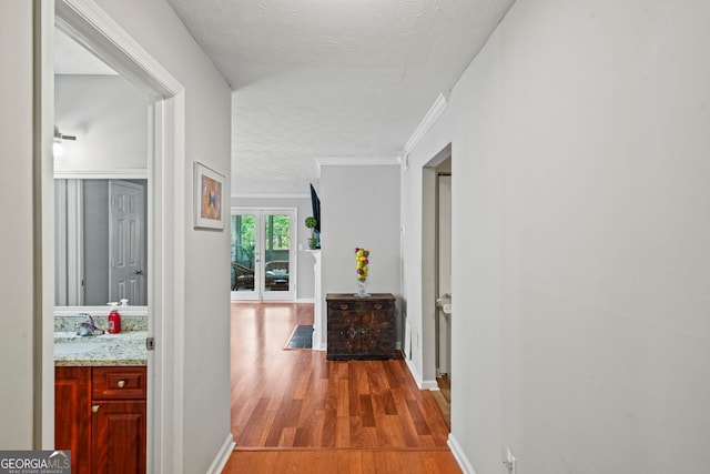 212 Brittany Ct, Duluth, GA 30096 - hall with wood finished floors, a textured ceiling, a sink, baseboards, and ornamental molding