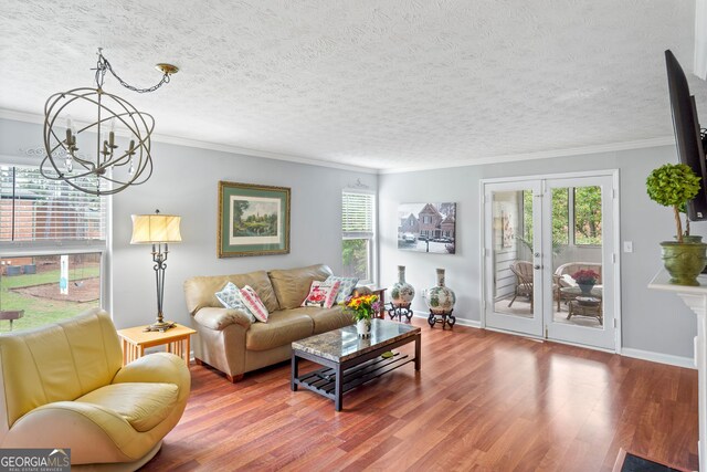 212 Brittany Ct, Duluth, GA 30096 - living area featuring a chandelier, wood finished floors, baseboards, french doors, and crown molding
