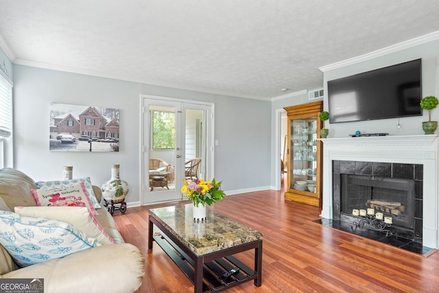 212 Brittany Ct, Duluth, GA 30096 - living area with wood finished floors, a tile fireplace, baseboards, a textured ceiling, and crown molding