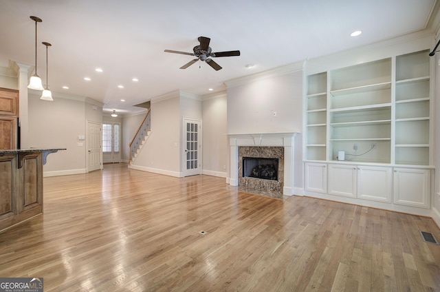 5492 Glenridge Dr Unit 536, Atlanta, GA 30342 - unfurnished living room featuring crown molding, ceiling fan, light wood-style floors, a high end fireplace, and stairway