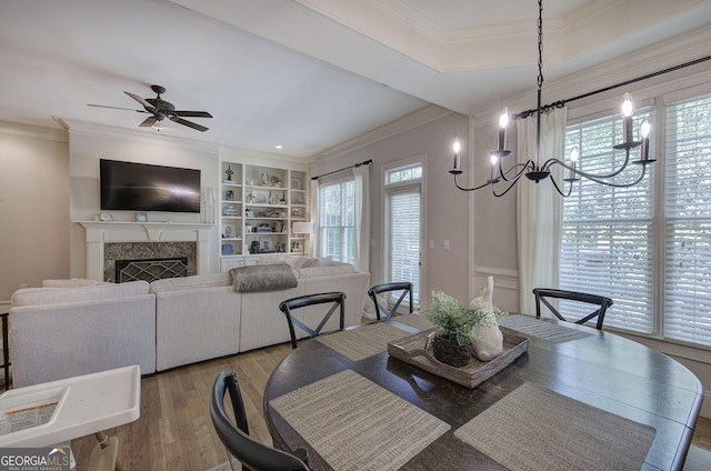 5492 Glenridge Dr Unit 536, Atlanta, GA 30342 - dining space featuring crown molding, ceiling fan, wood finished floors, a chandelier, and a fireplace
