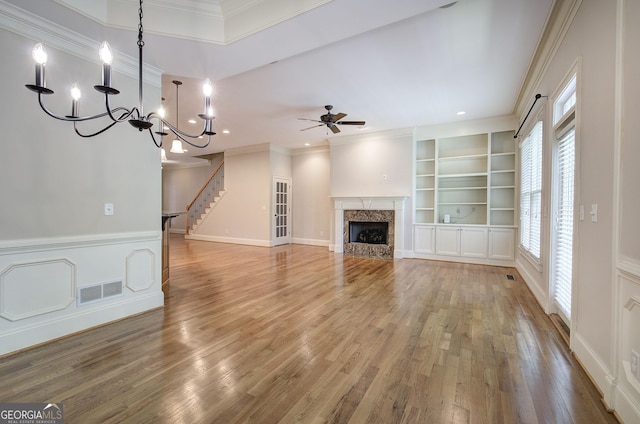 5492 Glenridge Dr Unit 536, Atlanta, GA 30342 - unfurnished living room with wood finished floors, crown molding, ceiling fan, a chandelier, and stairs