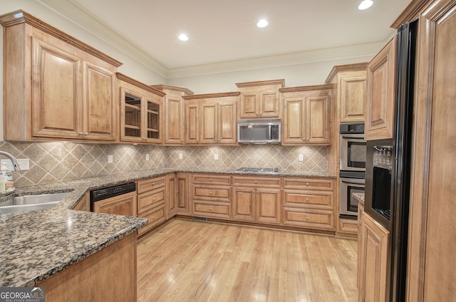5492 Glenridge Dr Unit 536, Atlanta, GA 30342 - kitchen with stainless steel appliances, a sink, light wood-type flooring, dark stone countertops, and ornamental molding
