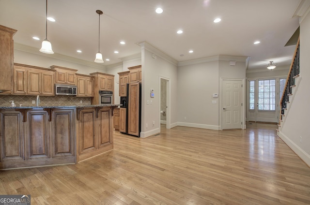 5492 Glenridge Dr Unit 536, Atlanta, GA 30342 - kitchen featuring appliances with stainless steel finishes, crown molding, a kitchen breakfast bar, a peninsula, and baseboards