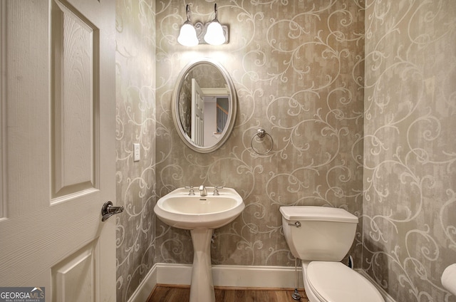 5492 Glenridge Dr Unit 536, Atlanta, GA 30342 - bathroom featuring wood finished floors, wallpapered walls, toilet, and baseboards