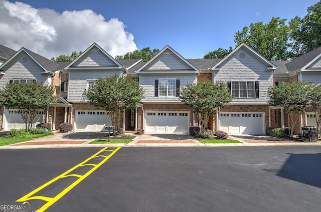 5492 Glenridge Dr Unit 536, Atlanta, GA 30342 - view of property featuring brick siding, a garage, and driveway