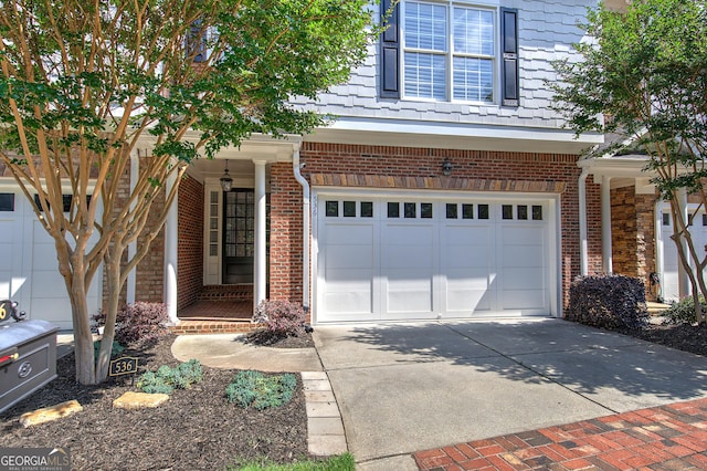 5492 Glenridge Dr Unit 536, Atlanta, GA 30342 - view of front of house featuring an attached garage, driveway, brick siding, and a porch
