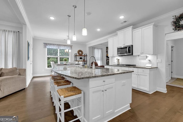 8745 Hightower Rdg, Ball Ground, GA 30107 - kitchen featuring stainless steel microwave, crown molding, a sink, backsplash, and light stone counters