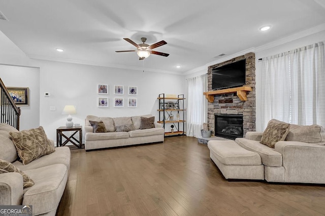 8745 Hightower Rdg, Ball Ground, GA 30107 - living area featuring a ceiling fan, a stone fireplace, stairs, ornamental molding, and wood finished floors