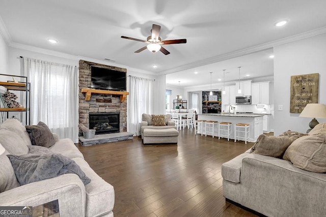 8745 Hightower Rdg, Ball Ground, GA 30107 - living area with a ceiling fan, ornamental molding, dark wood-style floors, a stone fireplace, and recessed lighting