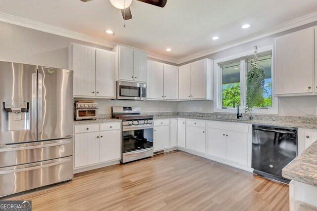 346 Rest Haven Rd, Thomaston, GA 30286 - kitchen featuring stainless steel appliances, crown molding, a ceiling fan, light wood finished floors, and light stone countertops