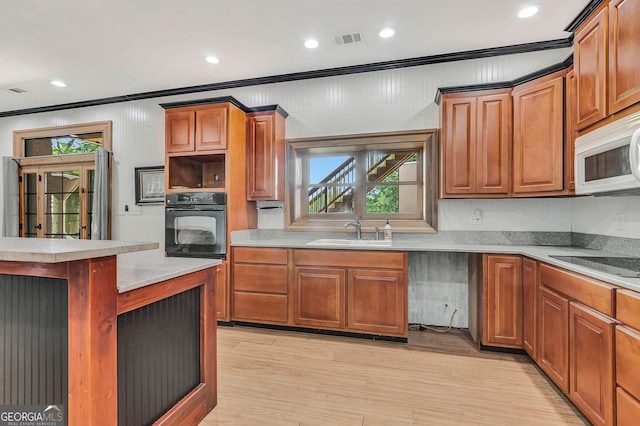346 Rest Haven Rd, Thomaston, GA 30286 - kitchen with black appliances, ornamental molding, a sink, light countertops, and light wood-style flooring