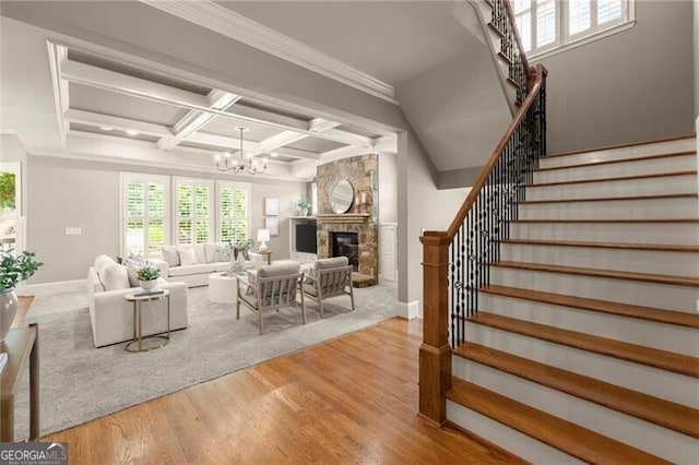 1286 Whisper Cove Dr, Buford, GA 30518 - living area with wood finished floors, stairs, a chandelier, coffered ceiling, and a stone fireplace