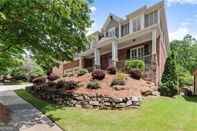 1286 Whisper Cove Dr, Buford, GA 30518 - craftsman house featuring brick siding, a front lawn, and a porch
