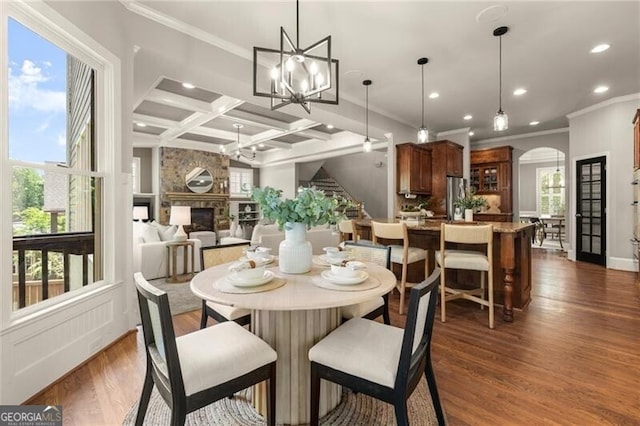 1286 Whisper Cove Dr, Buford, GA 30518 - dining area featuring crown molding, arched walkways, plenty of natural light, coffered ceiling, and dark wood finished floors