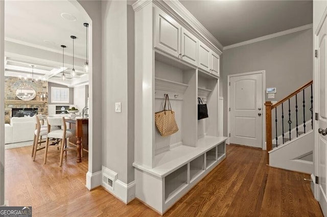 1286 Whisper Cove Dr, Buford, GA 30518 - mudroom with ornamental molding, wood finished floors, a fireplace, and arched walkways