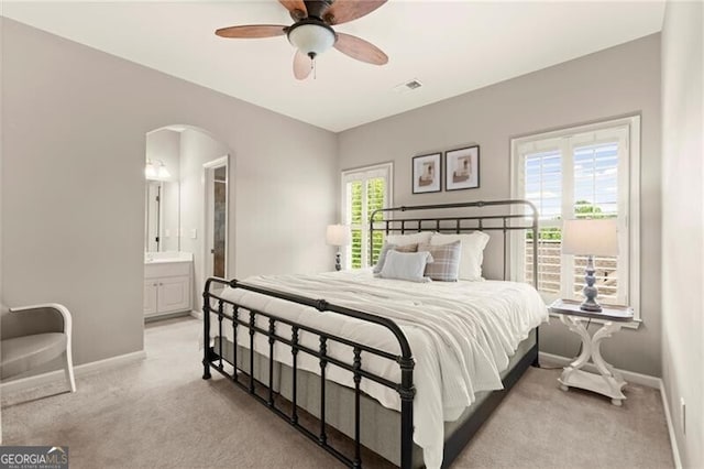 1286 Whisper Cove Dr, Buford, GA 30518 - bedroom with light colored carpet, arched walkways, ensuite bath, and a ceiling fan