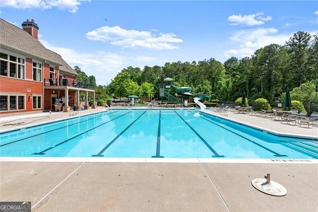 1286 Whisper Cove Dr, Buford, GA 30518 - community pool with a water slide and a patio area