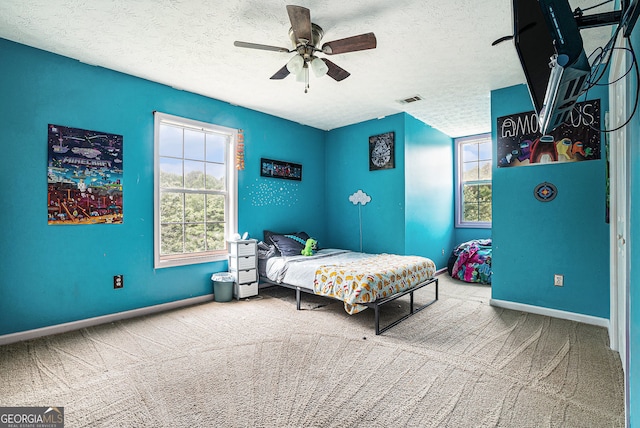 1235 Waterwood Dr, Loganville, GA 30052 - carpeted bedroom with multiple windows, a textured ceiling, and ceiling fan