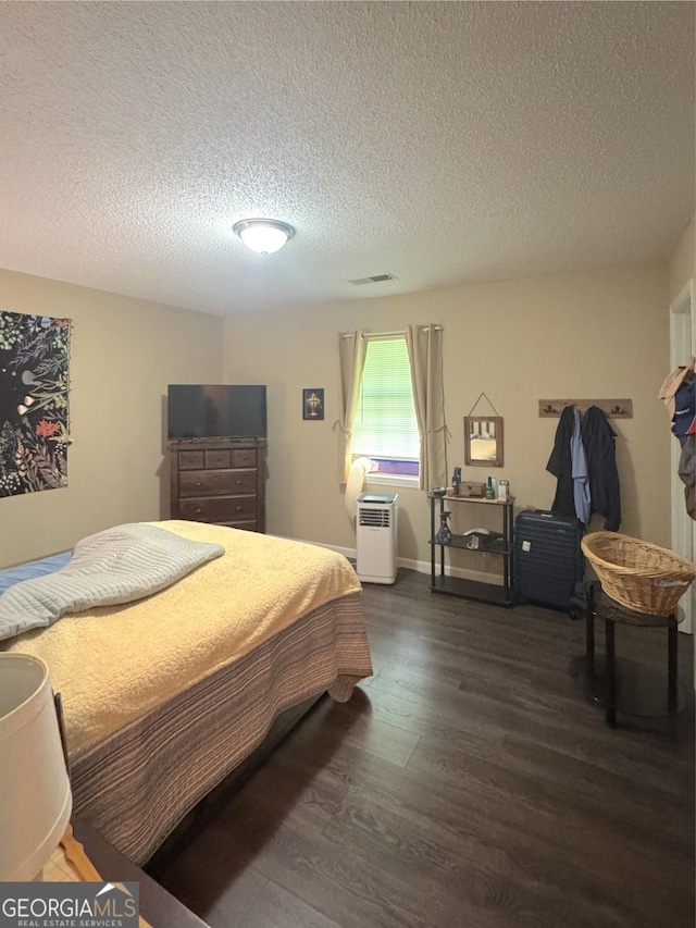 bedroom with dark wood-style floors and a textured ceiling