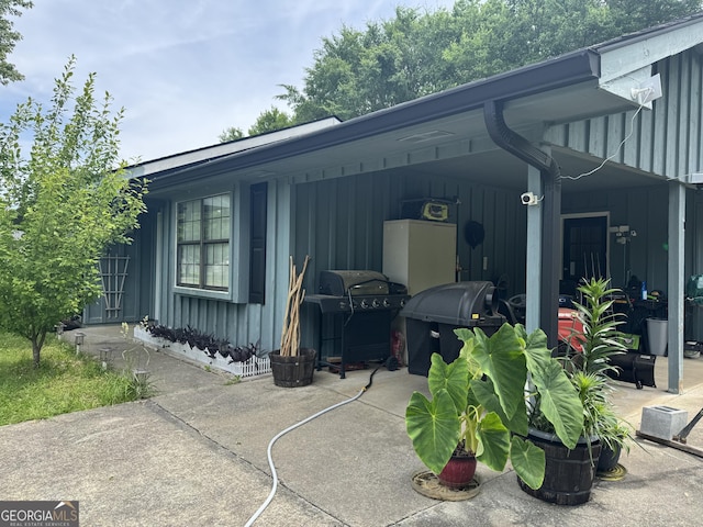 view of property exterior with board and batten siding and an attached carport
