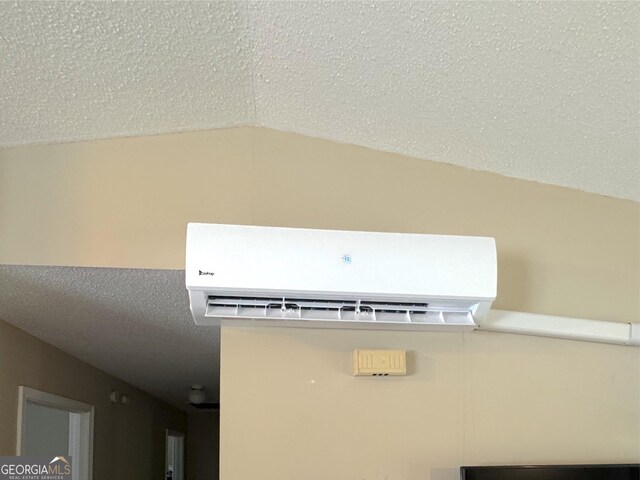 detailed view of a wall mounted air conditioner and a textured ceiling