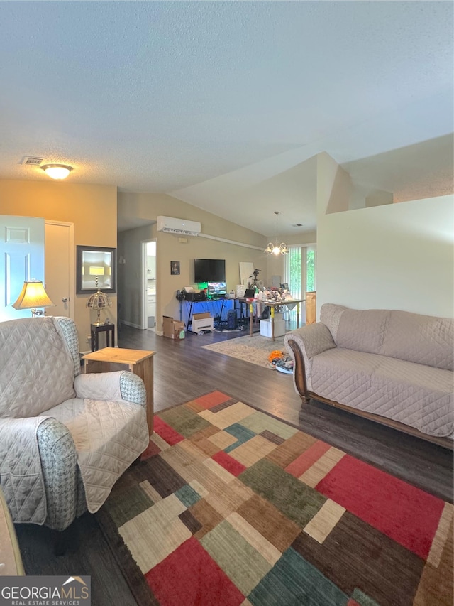 living room with wood finished floors, lofted ceiling, a wall unit AC, and a textured ceiling