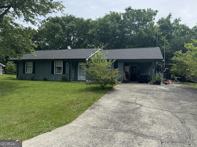ranch-style house featuring board and batten siding, concrete driveway, a front yard, and a carport