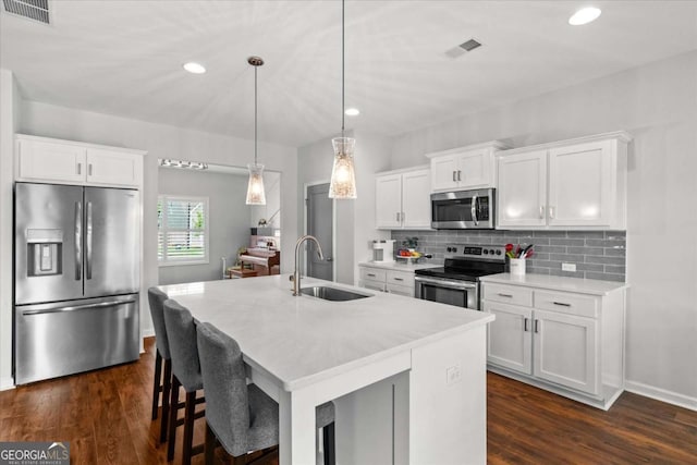 123 Cedar Park Way, Carrollton, GA 30117 - kitchen featuring stainless steel appliances, light countertops, a sink, a kitchen island with sink, and backsplash
