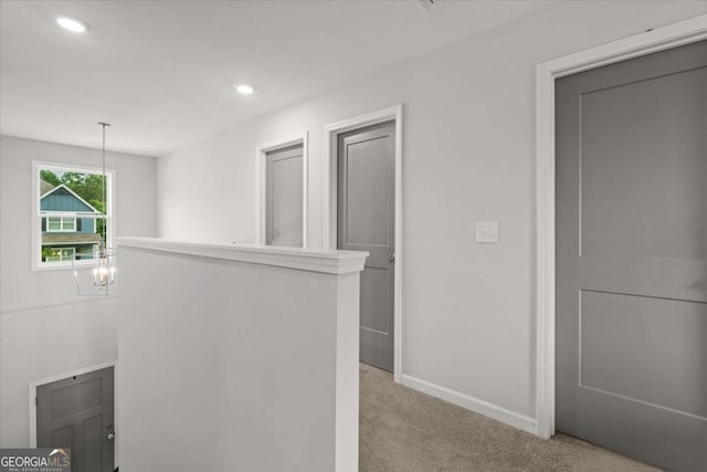 123 Cedar Park Way, Carrollton, GA 30117 - hallway with light colored carpet, baseboards, recessed lighting, a chandelier, and an upstairs landing
