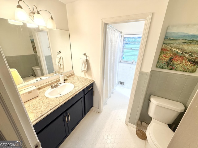 3095 Holbrook Dr SW, Marietta, GA 30060 - bathroom with toilet, vanity, tile patterned flooring, tile walls, and wainscoting