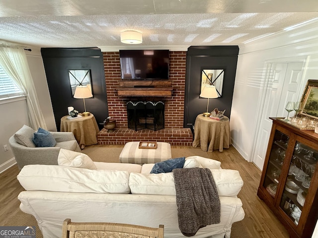 3095 Holbrook Dr SW, Marietta, GA 30060 - living area with a brick fireplace, wood finished floors, baseboards, a textured ceiling, and ornamental molding