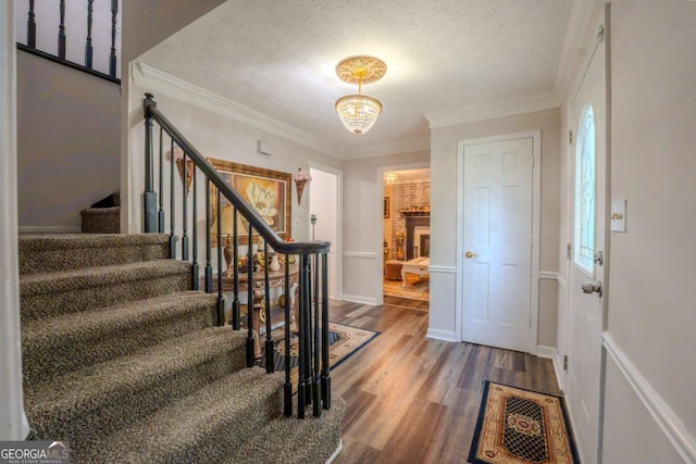 5293 Sandy Shoals Ln, Stone Mountain, GA 30087 - entrance foyer with stairs, wood finished floors, a textured ceiling, and crown molding