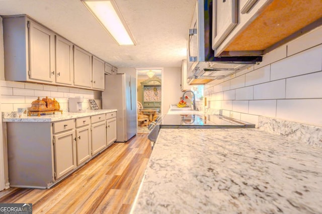 5293 Sandy Shoals Ln, Stone Mountain, GA 30087 - kitchen with tasteful backsplash, freestanding refrigerator, light countertops, light wood finished floors, and a sink